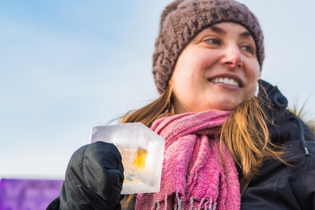 Foto midde volwassen vrouw met een drankje terwijl ze tegen de lucht staat tijdens de winter