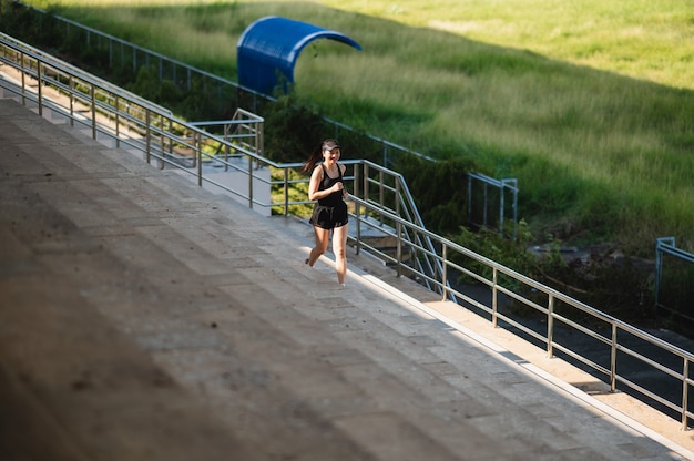 middelbare leeftijd Mooie Sport Aziatische vrouw buiten Runner atleet draait op Stadium trappen actieve en gezonde levensstijl.