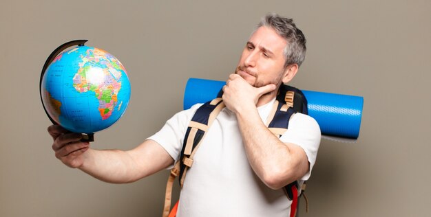 Middelbare leeftijd reiziger man met een wereldbol kaart