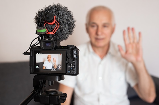Middelbare leeftijd senior mannelijke blogger video-opname thuis