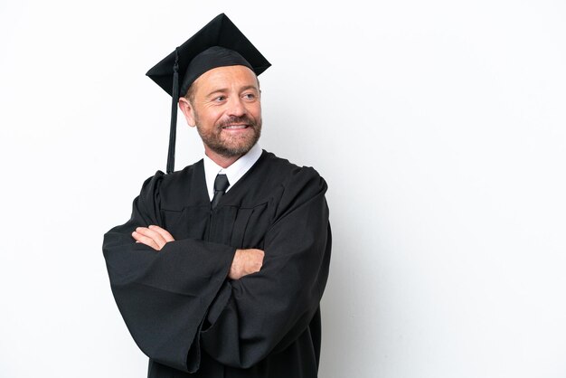 Middelbare leeftijd universitair afgestudeerde man geïsoleerd op een witte achtergrond met gekruiste armen en happy