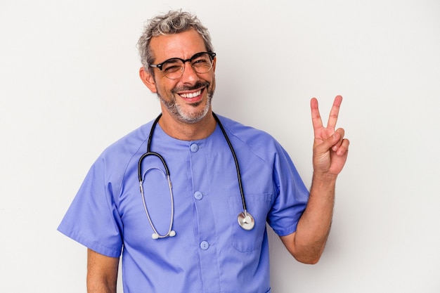 Middelbare leeftijd verpleegster blanke man geïsoleerd op witte achtergrond blij en zorgeloos met een vredessymbool met vingers.
