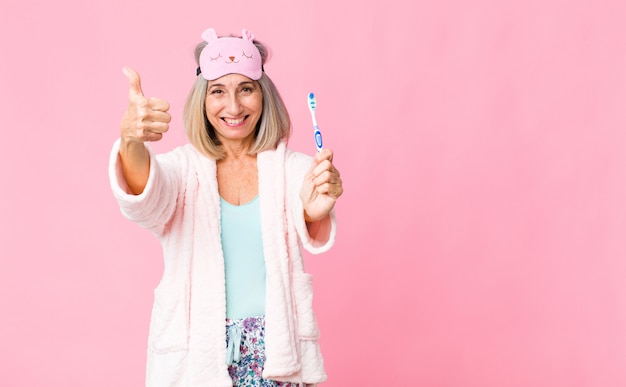 Middelbare leeftijd vrouw draagt nacht pak met een tandenborstel