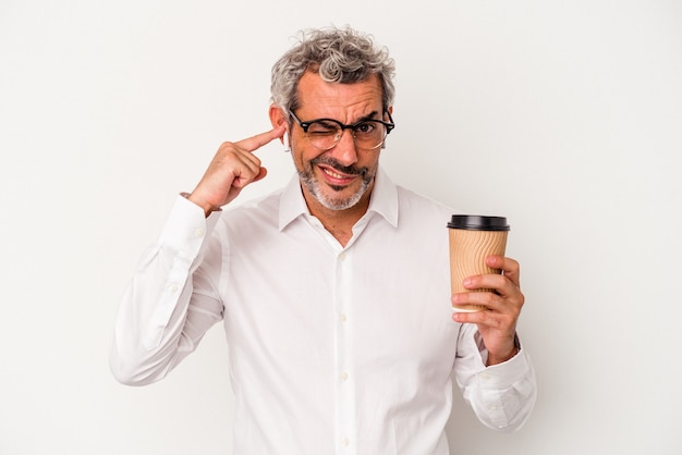 Middelbare leeftijd zakenman met een take-away koffie geïsoleerd op een witte achtergrond die oren bedekt met handen.