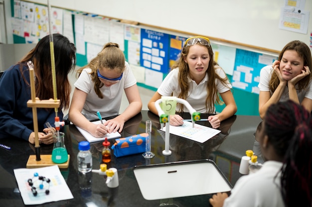 Middelbare schoolstudenten die in het klassenklasse van het chemielaboratorium bestuderen