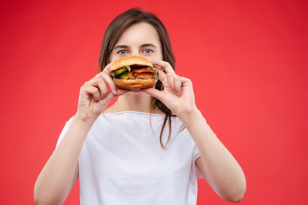 Middelgroot close-upportret van mooie jonge maniervrouw die verse smakelijke sandwich bijten