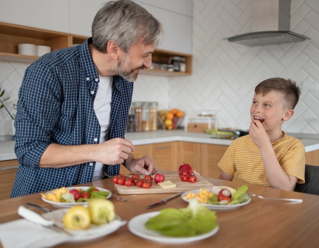 Middelgroot geschoten kind en ouder met eten