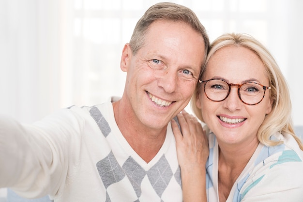 Foto middelgroot schot gelukkig paar die een selfie nemen