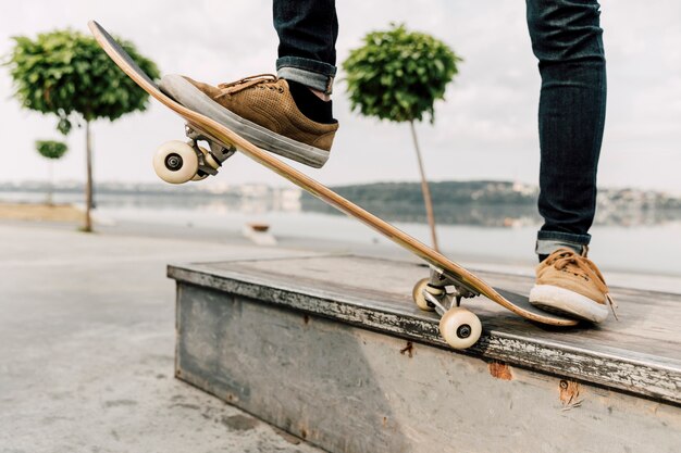 Middelgroot schot van mens het in evenwicht brengen op skateboard