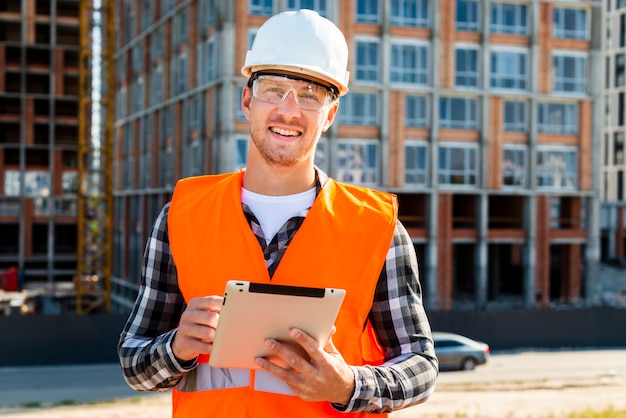 Middelgrote geschoten bouwingenieur die tablet gebruiken