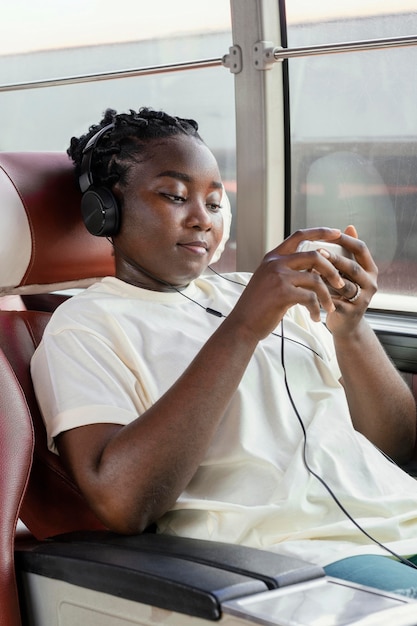 Foto middelgrote geschoten vrouw met hoofdtelefoons in bus