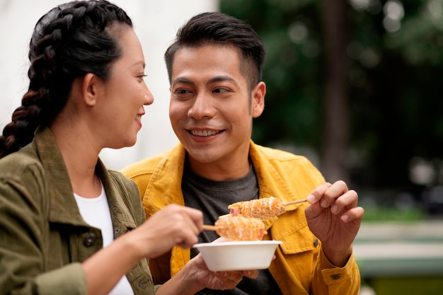 Foto middelgrote mensen die maïshond eten