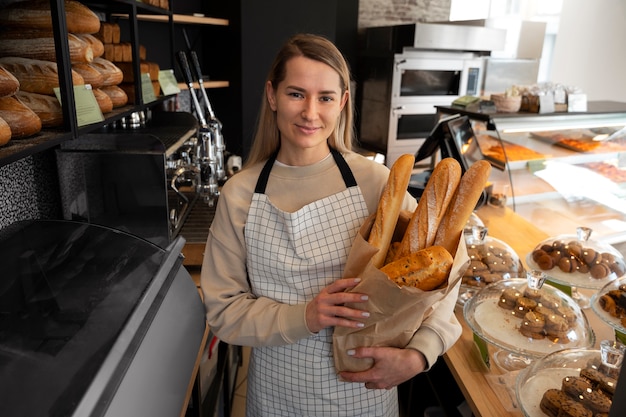 Foto middellange geschotene vrouw die in bakkerij werkt