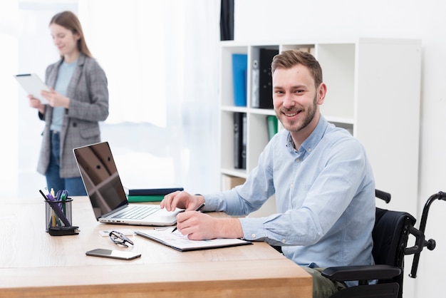 Middellange shot smiley man binnenshuis werken