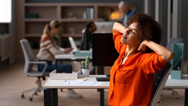 Middellange shot vrouw die zich uitstrekt op het werk