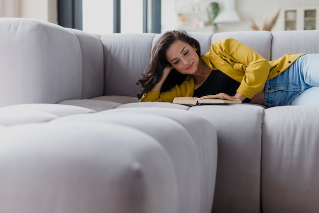 Foto middellange shot vrouw lezen op de bank