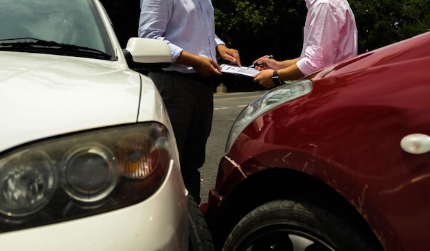 Middels sectie van mannen die papierwerk doen terwijl ze bij auto's staan