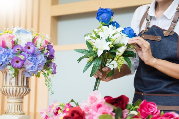 Foto middelsectie van bloemhandelaar met bloemen in de winkel