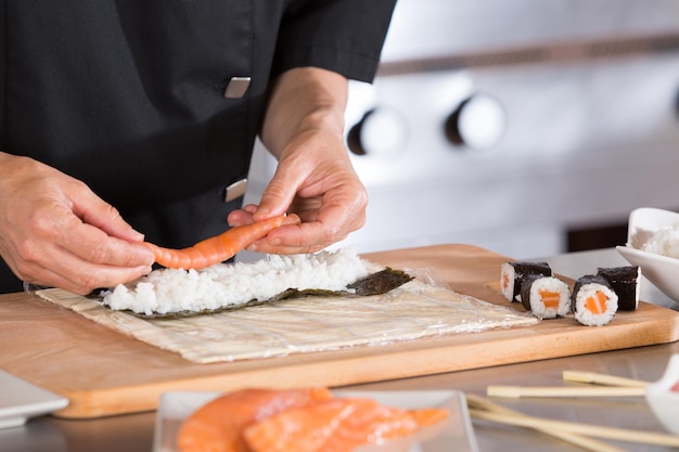 Foto middelsectie van chef-kok die sushi bereidt in een commerciële keuken