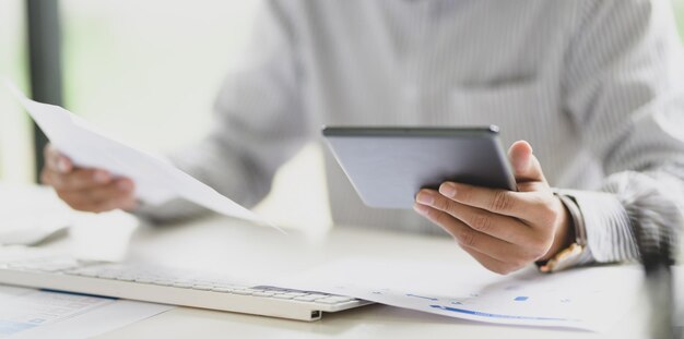 Middelsectie van een man die een laptop op tafel gebruikt