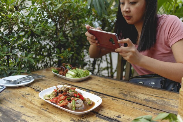 Foto middelsectie van een man die een mobiele telefoon op tafel gebruikt