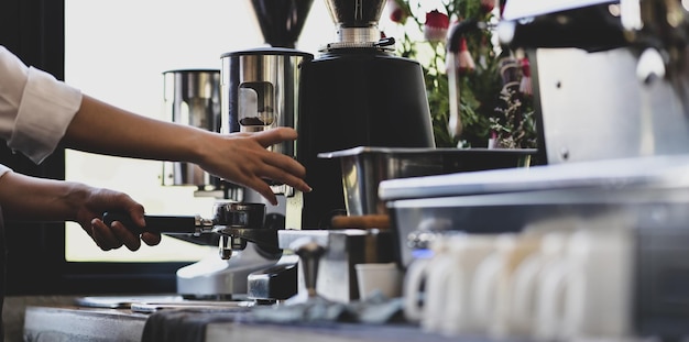 Middelsectie van een man die koffie bereidt in de keuken