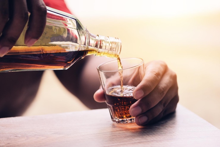 Foto middelsectie van een man die op tafel een glas drinkt