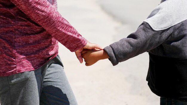 Foto middelsectie van een paar dat elkaars hand vasthoudt