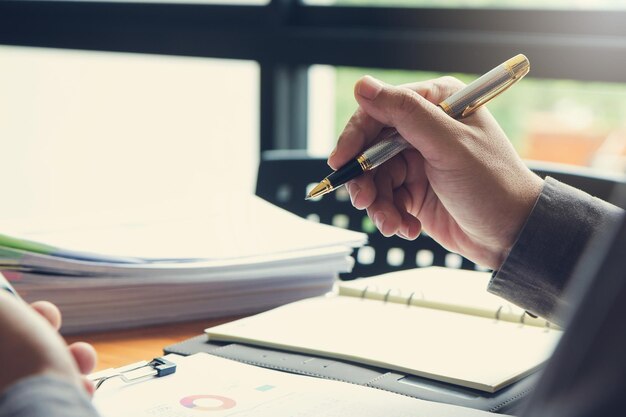 Foto middelsectie van een persoon die een smartphone op tafel houdt