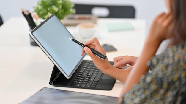 Middelsectie van een vrouw die een mobiele telefoon op tafel gebruikt