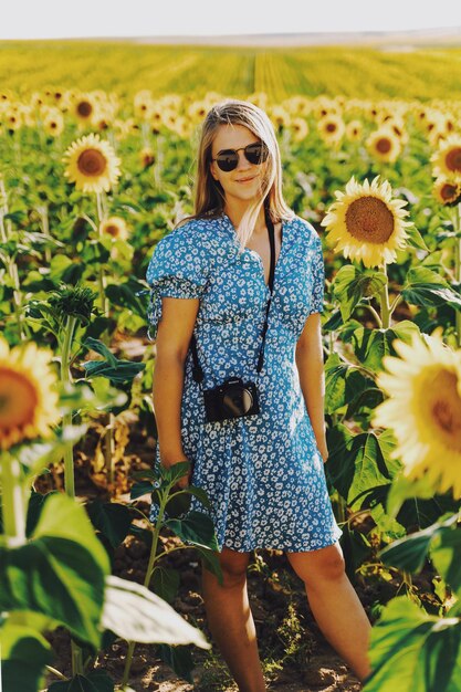 Foto middelsectie van een vrouw die in een zonnebloemveld staat