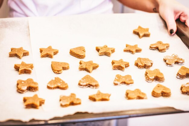 Middelsectie van een vrouw die koekjes bereidt in de keuken