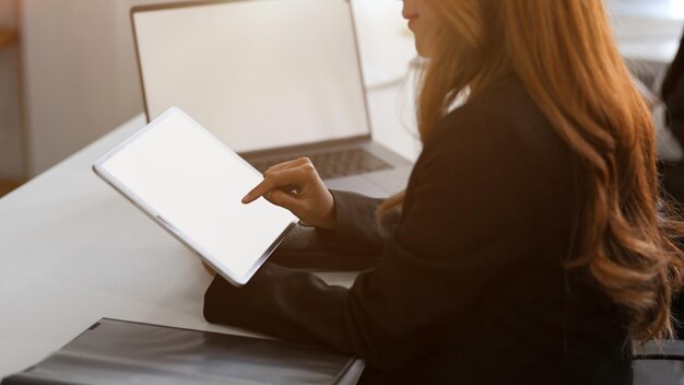 Middelsectie van een vrouw die thuis een laptop gebruikt