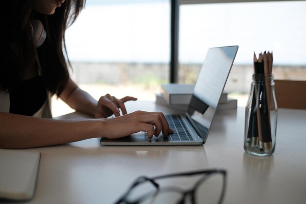 Middelsectie van een vrouw met een laptop op tafel