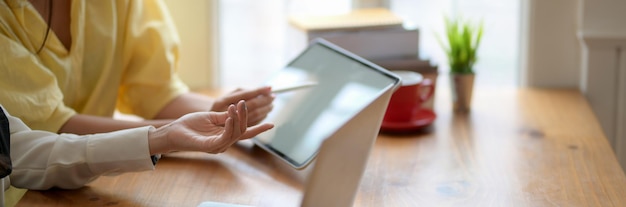 Middelsectie van een vrouw met een smartphone thuis