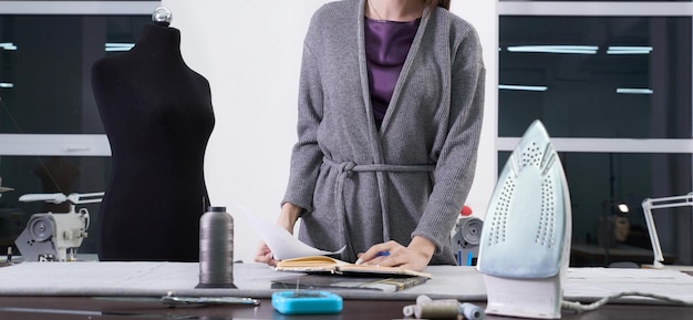 Middelsectie van modeontwerper die bij tafel staat