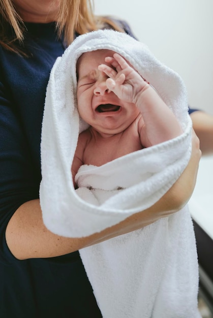 Middelsectie van moeder die zoon in de handdoek in de badkamer houdt