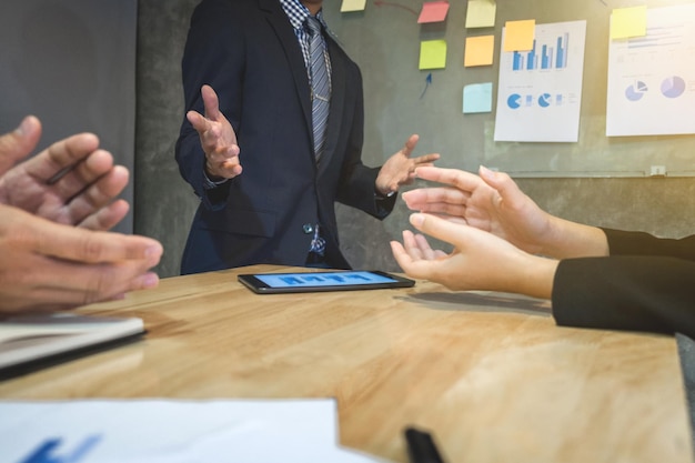 Middelsection van collega's die aan tafel in de vergaderzaal discussiëren