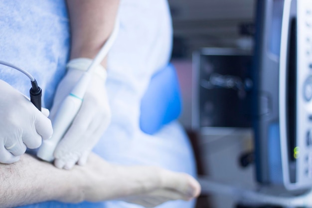 Foto middelsnede van een arts die het been van een patiënt in het ziekenhuis onderzoekt