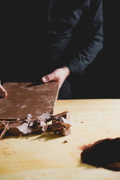 Foto middelsnede van een man die chocolade breekt.