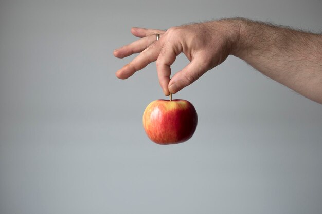 Foto middelsnede van een man die een appel vasthoudt op een witte achtergrond