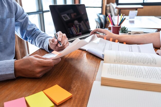 Middelsnede van een man die een boek op tafel leest