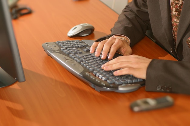 Foto middelsnede van een man die een computer op zijn bureau gebruikt