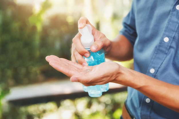 Middelsnede van een man die een fles vasthoudt tegen een wazige achtergrond