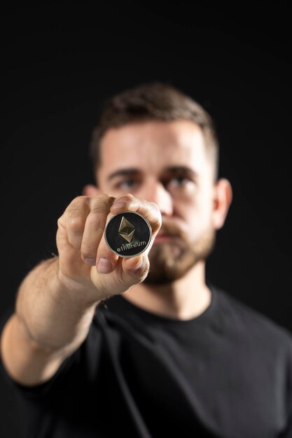 Foto middelsnede van een man die een horloge vasthoudt tegen een zwarte achtergrond