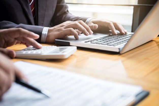 Middelsnede van een man die een laptop op tafel gebruikt