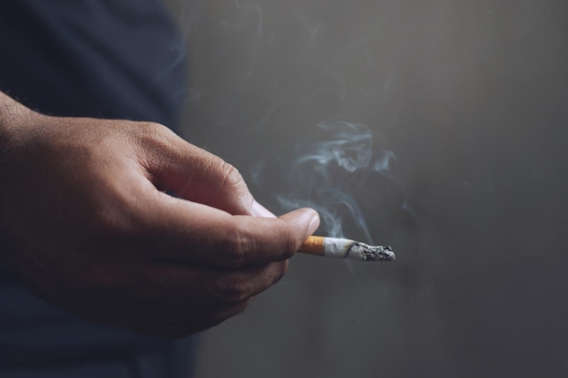 Middelsnede van een man die een sigaret rookt