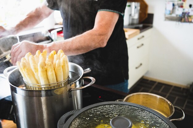 Middelsnede van een man die eten bereidt in de keuken