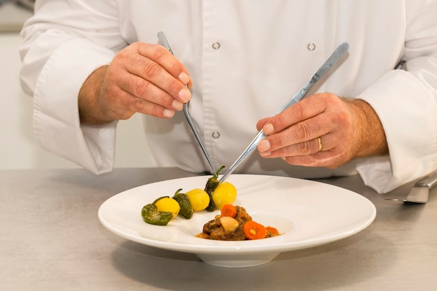 Foto middelsnede van een man die eten bereidt in een bord op tafel