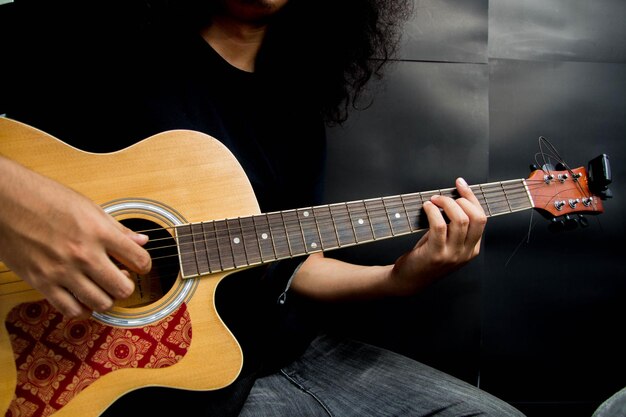 Foto middelsnede van een man die gitaar speelt